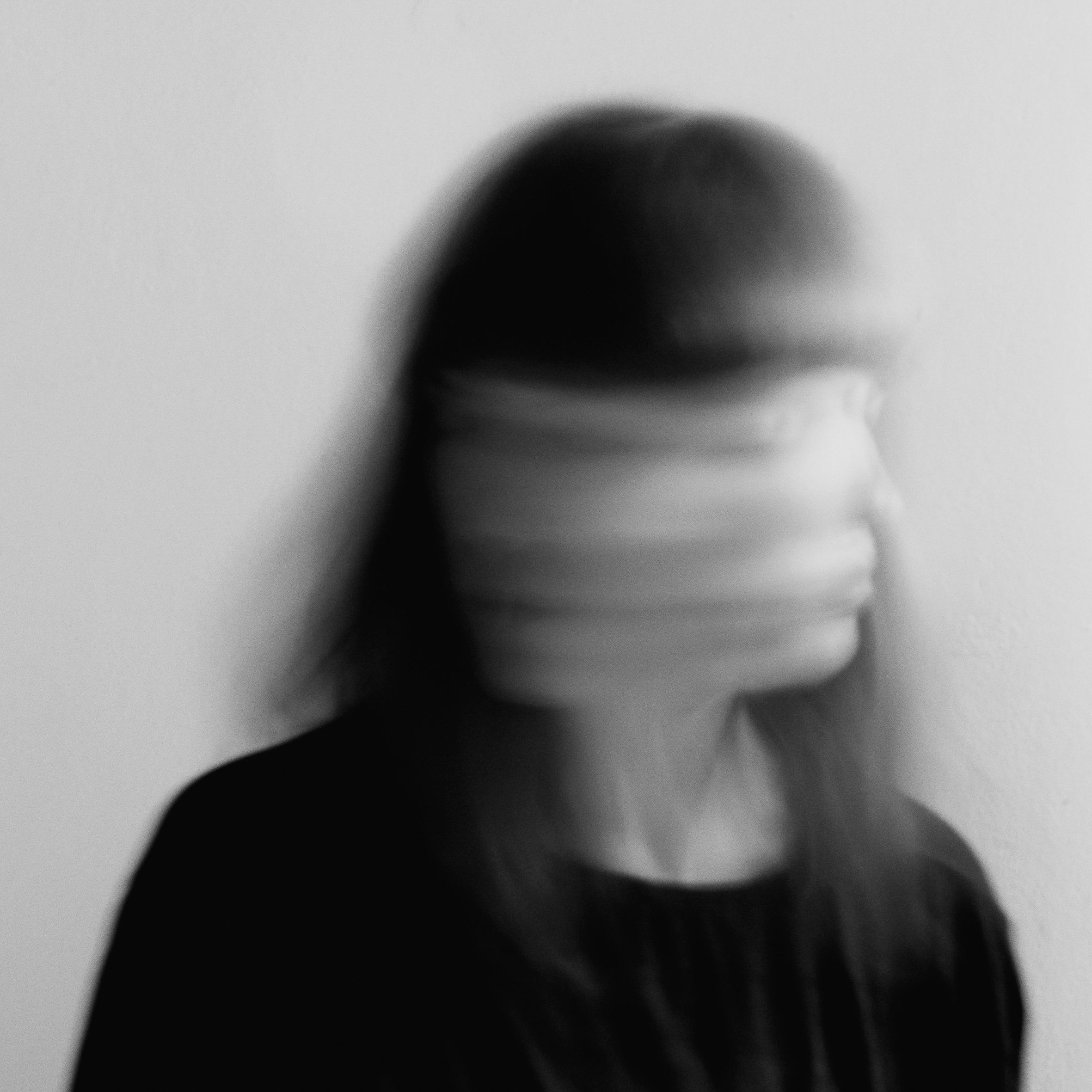 Black-and-white studio portrait of a woman in motion, minimal and artistic