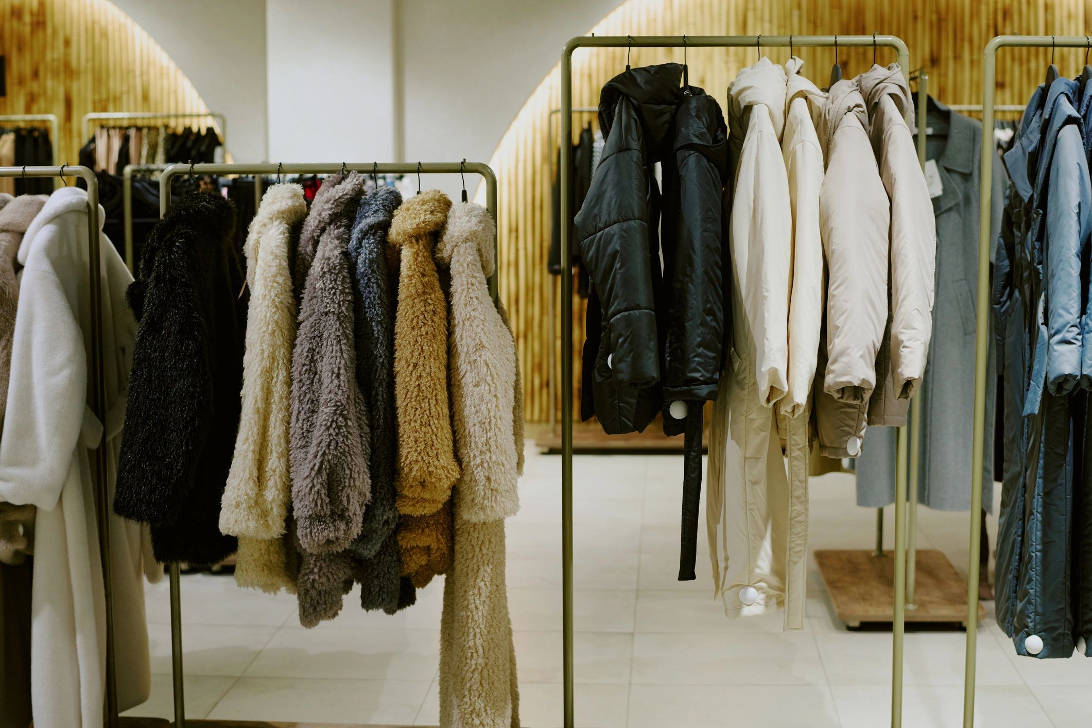 Minimal boutique clothing rack with neutral outerwear