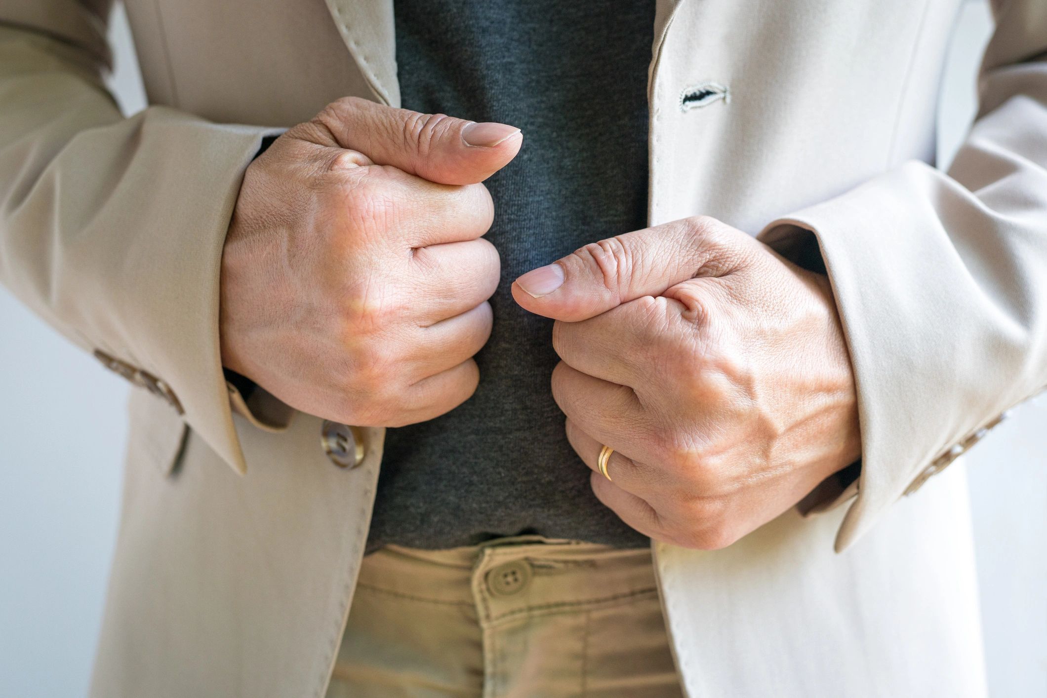 Close-up of hands adjusting a blazer, minimal fashion detail